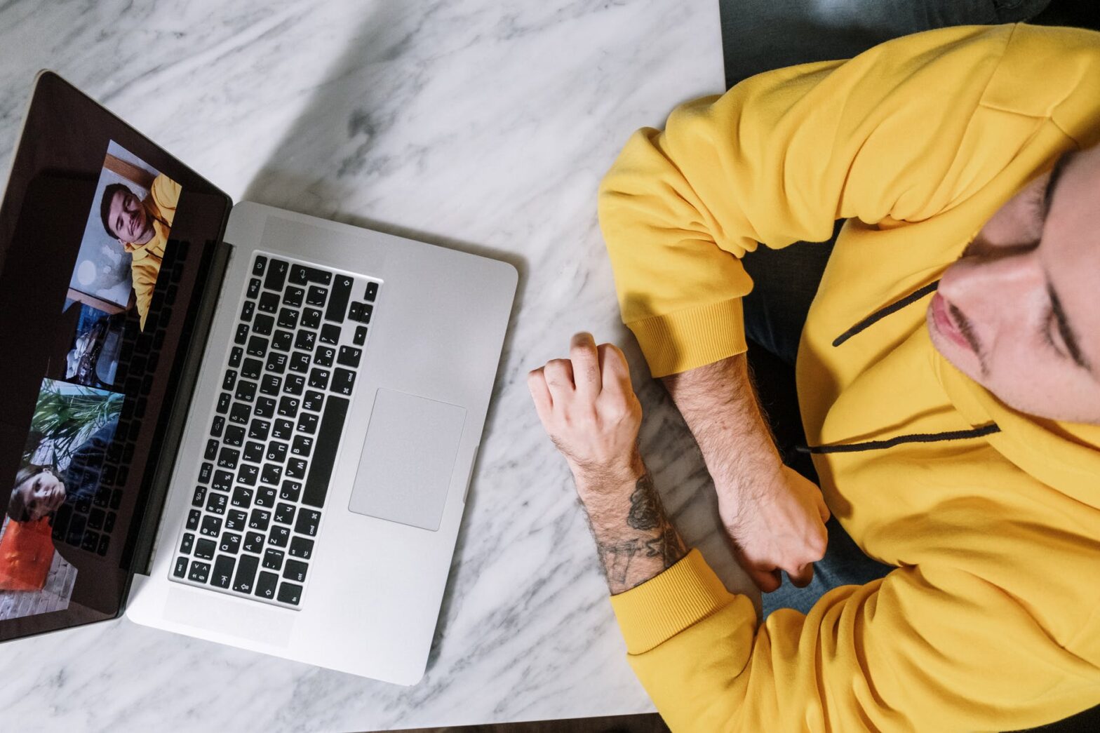 person in yellow long sleeve shirt using macbook pro